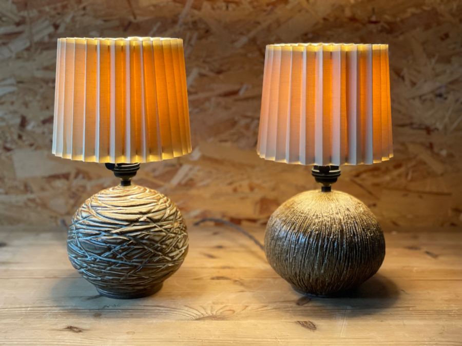 Two carved globe ceramic lamps glowing warm