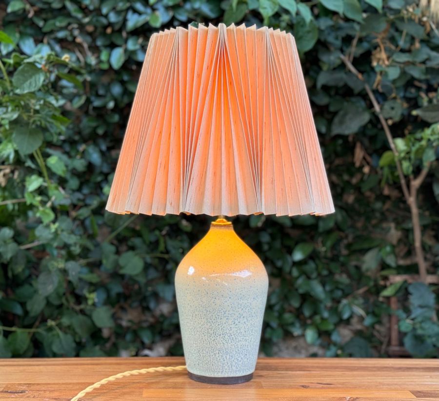 Speckled blue amber lamp with pink pleated shade outdoors