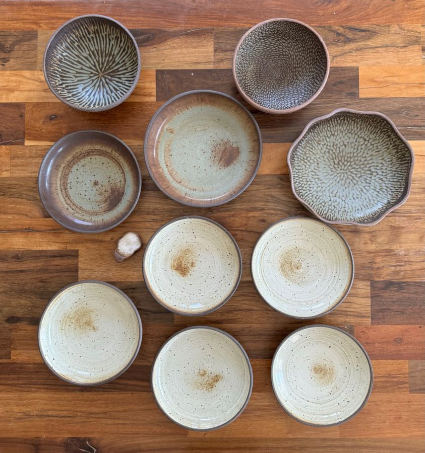 Flat lay of mixed bowls and plates on wood