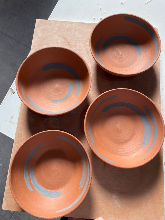 Four terracotta bowls with grey slip swirls